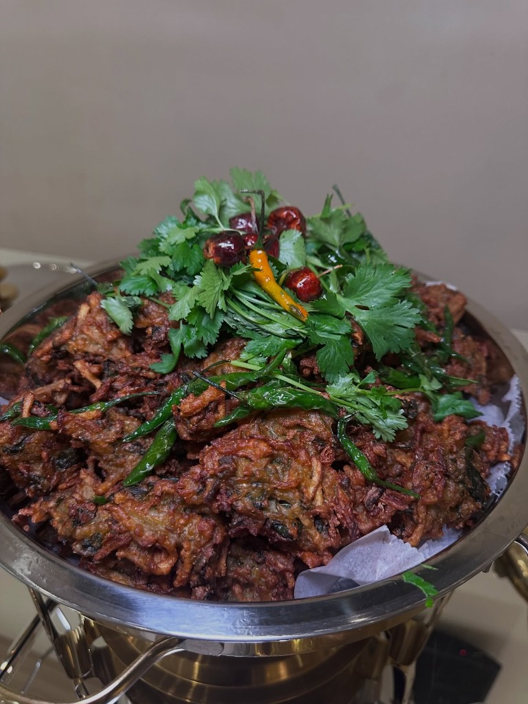 Crispy onion bhajia topped with fresh cilantro and green chilis
