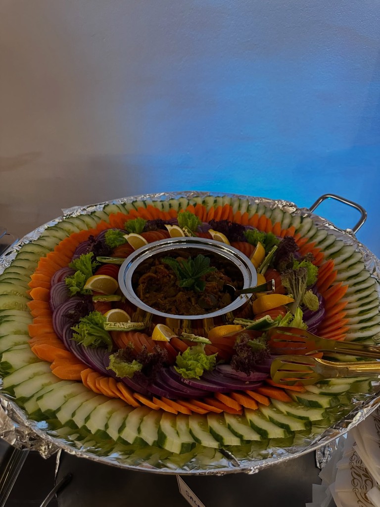 Artfully arranged vegetable platter with sliced cucumbers, carrots and onions